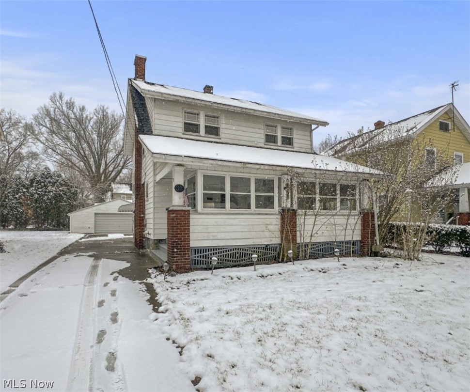 View of front of house featuring a sunroom and a chimney