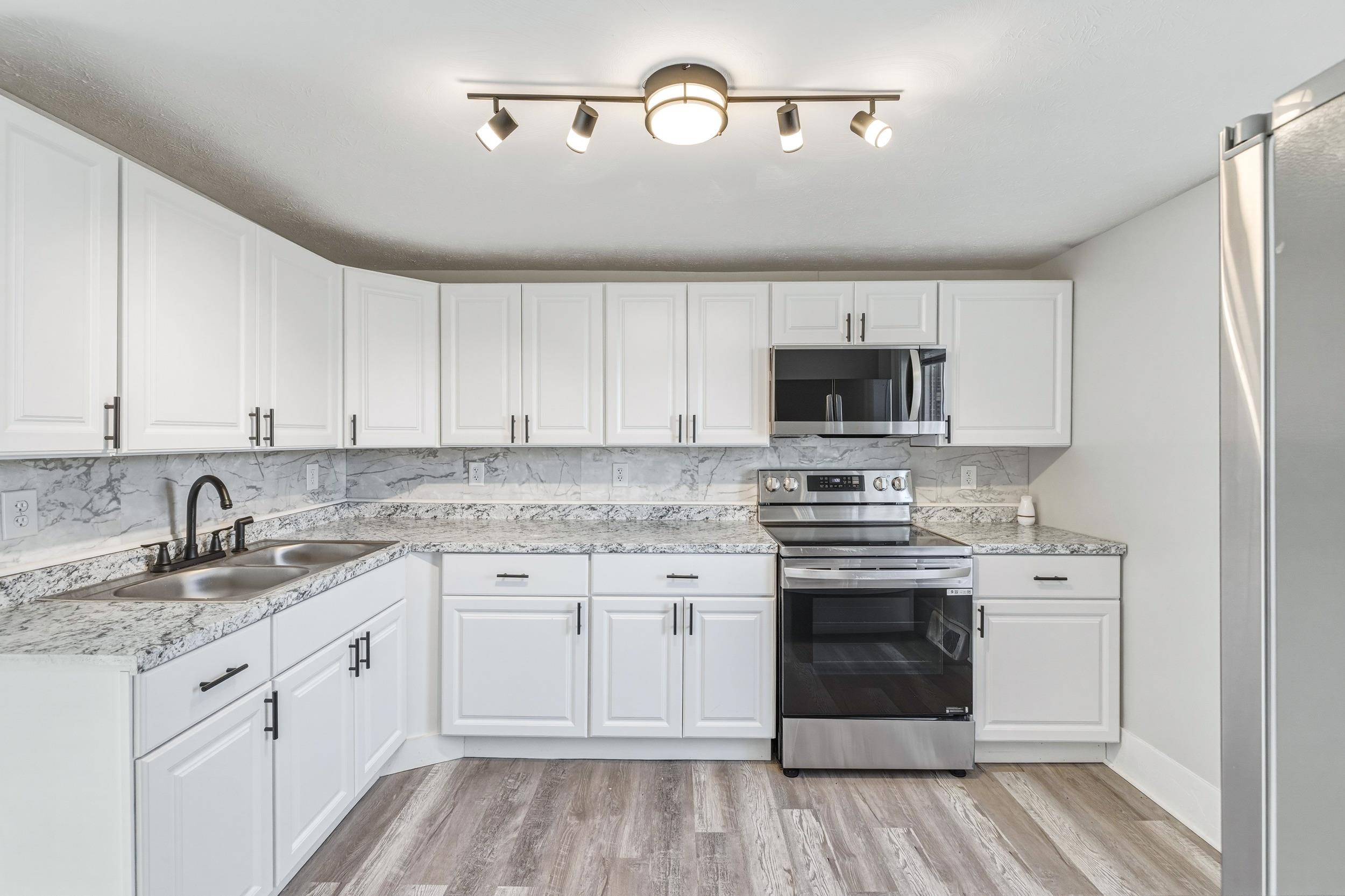 773 West Main Street Stanley, VA 22851 - Photo 3 of 66 a kitchen with granite countertop white cabinets and white appliances