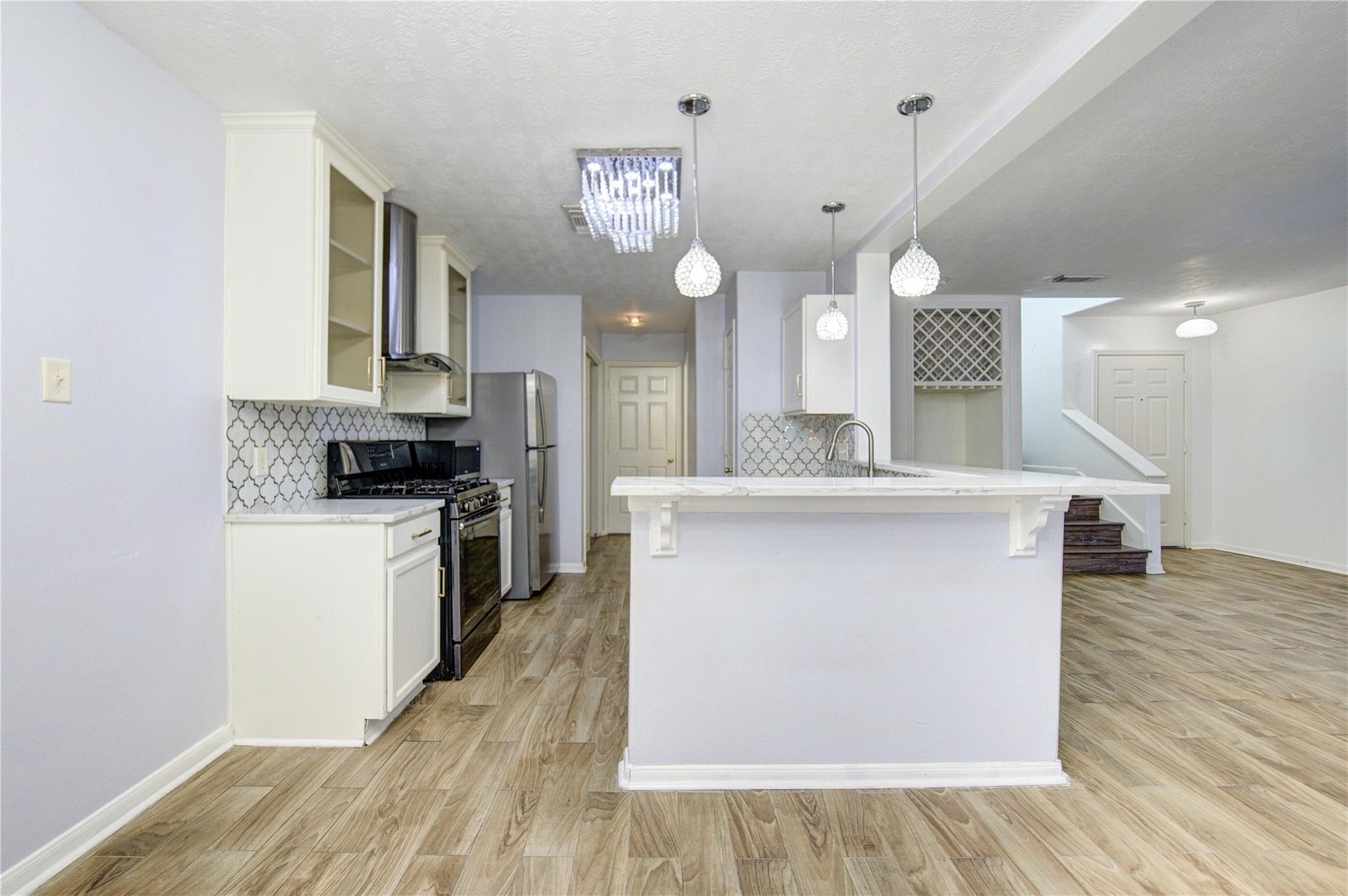 19334 Strathmore Pl Lane Katy, TX 77449 - Photo 36 of 48 a large kitchen with stainless steel appliances a large counter top a stove a microwave a sink and a refrigerator