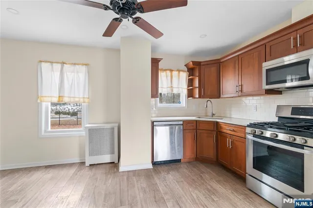 a kitchen with stainless steel appliances granite countertop a stove a sink and a microwave