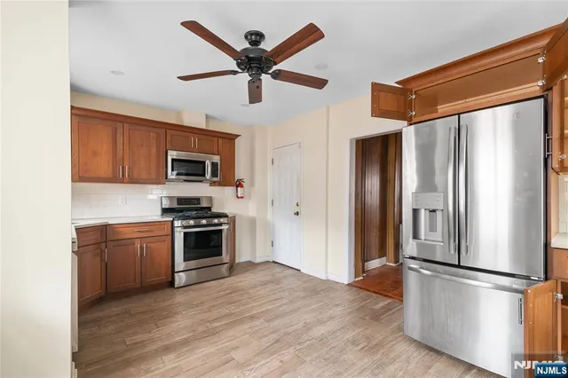 a kitchen with stainless steel appliances granite countertop a refrigerator a stove top oven a sink and dishwasher