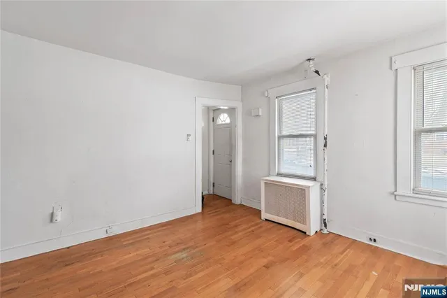 an empty room with cabinet and windows