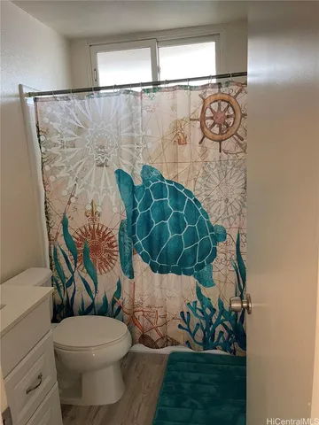 a bathroom with a toilet and a shower curtain
