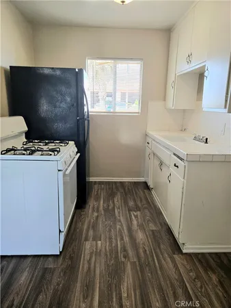 a kitchen with a sink and wooden floor