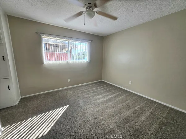 an empty room with closet and a chandelier fan