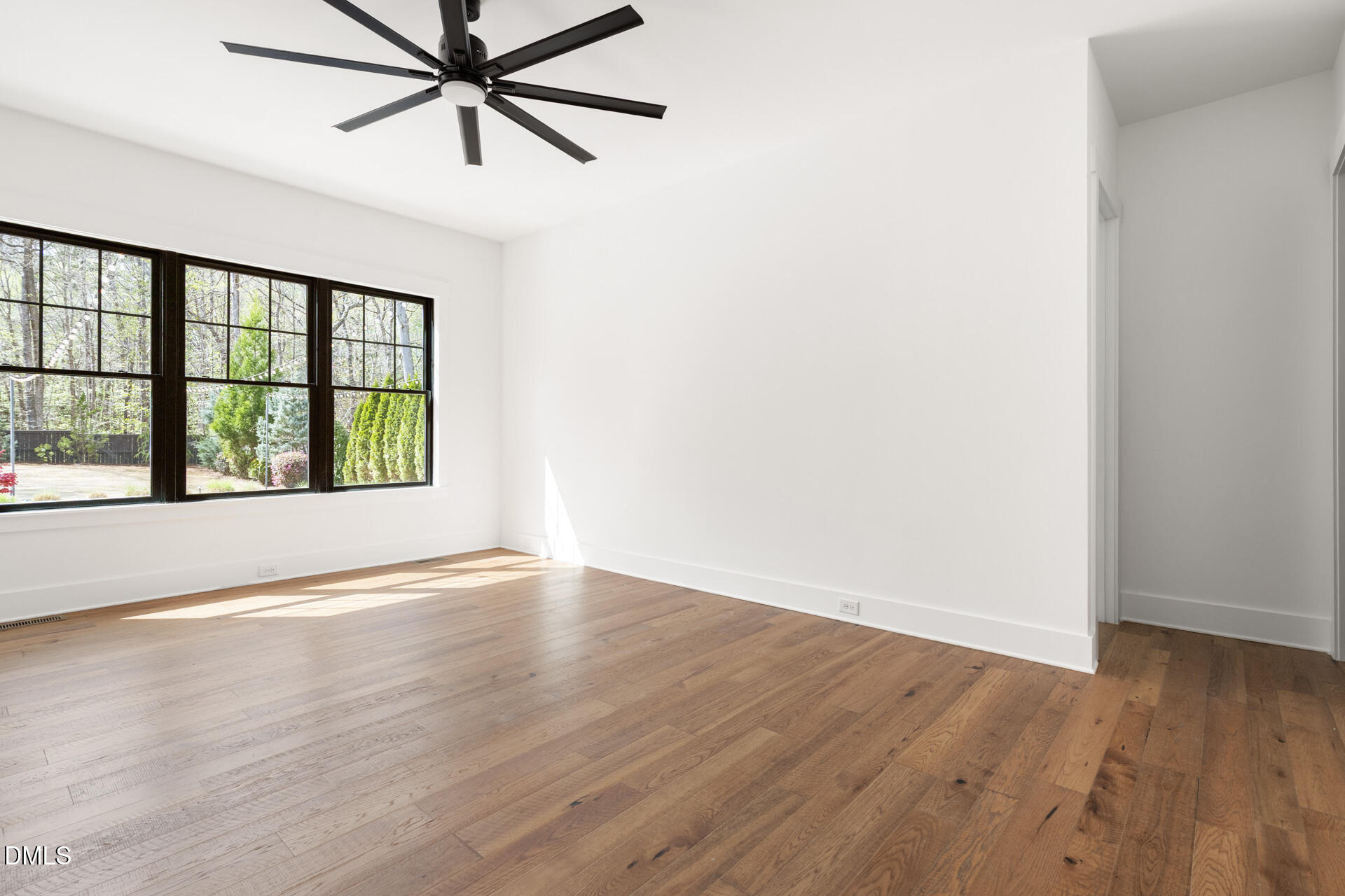 1117 Barley Stone Way Raleigh, NC 27603 - Photo 25 of 59 an empty room with wooden floor fan and windows