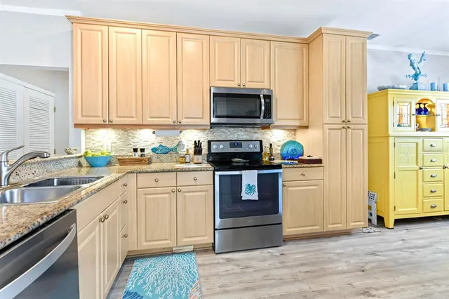 a kitchen with a refrigerator a sink and cabinets