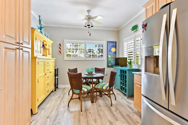 a kitchen with stainless steel appliances a refrigerator a table and chairs