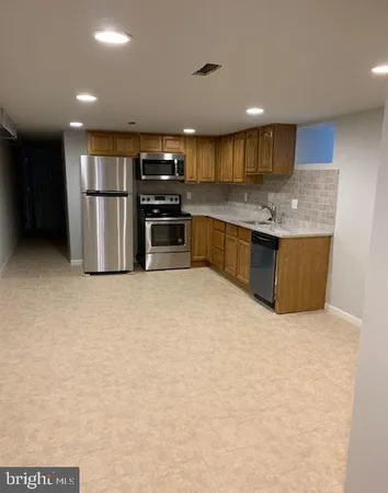 a kitchen with stainless steel appliances granite countertop a refrigerator and a sink