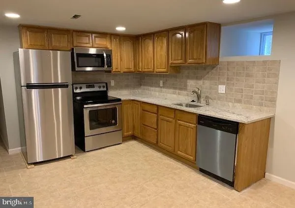 a kitchen with stainless steel appliances granite countertop a refrigerator sink and microwave