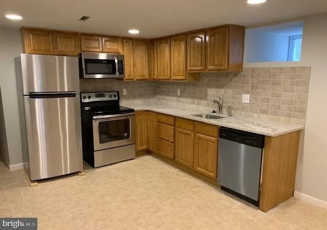 a kitchen with stainless steel appliances granite countertop a refrigerator sink and microwave