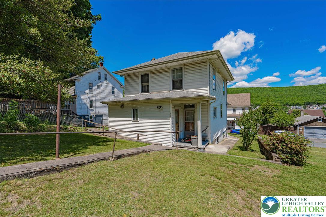 159 West Ridge Street Nesquehoning, PA 18240 - Photo 41 of 55 A classic two-story residence with a charming front porch, set on a verdant hillside with mountain views.