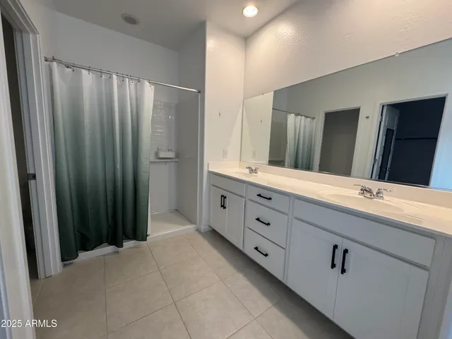 a bathroom with a double vanity sink and a mirror