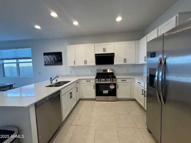 a large kitchen with a refrigerator sink and stove