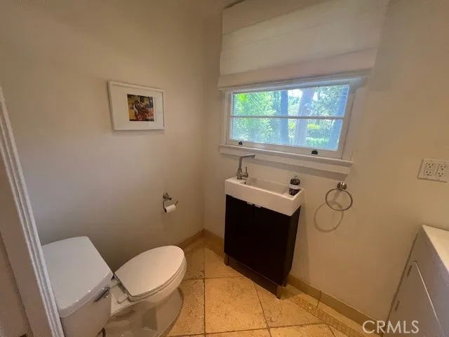 a bathroom with a toilet a sink and mirror