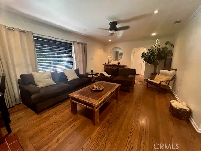 a living room with furniture and a wooden floor