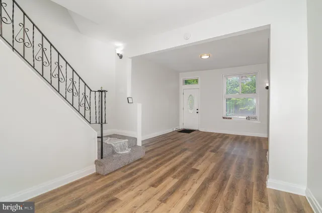 a view of a hallway with wooden floor and entryway