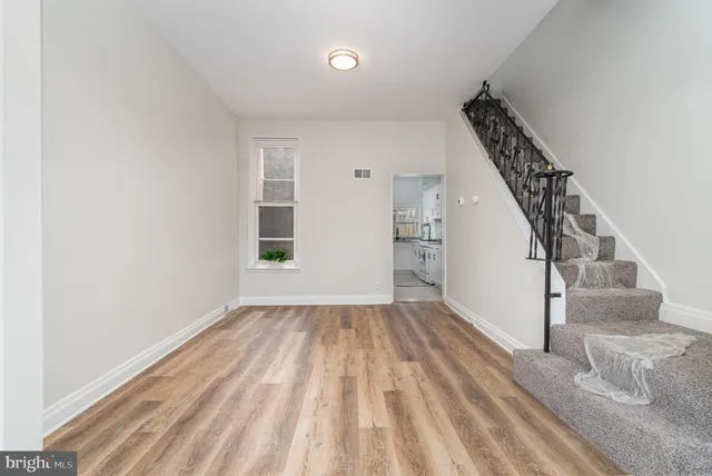 a view of empty room with wooden floor