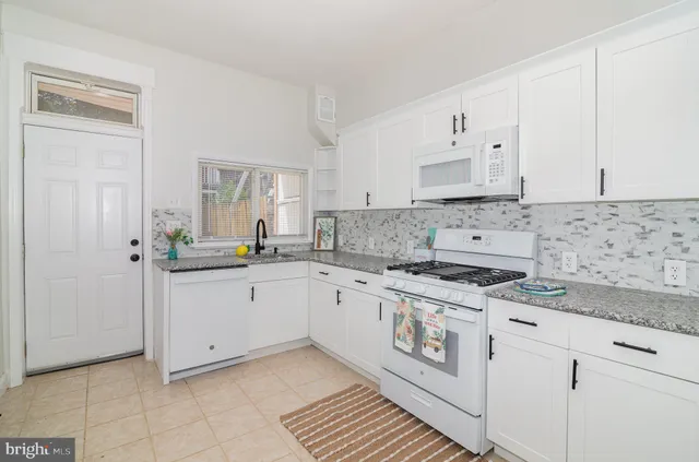 a kitchen with a stove a sink and a window