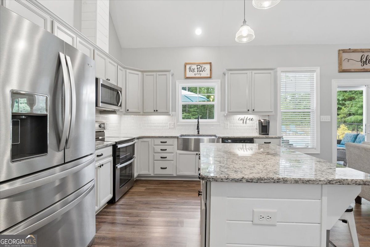 683 Teagle Road Forsyth, GA 31029 - Photo 13 of 50 a kitchen with stainless steel appliances granite countertop a sink stove and refrigerator