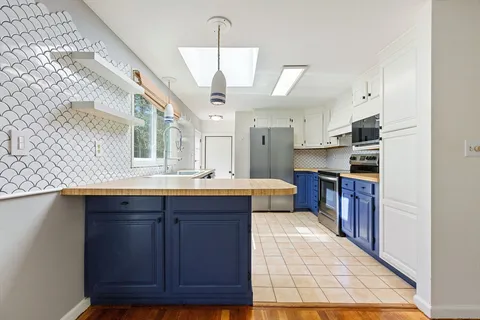 a large kitchen with stainless steel appliances granite countertop a stove a sink dishwasher and a refrigerator
