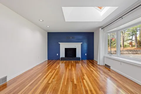 a view of an empty room with a fireplace and a window