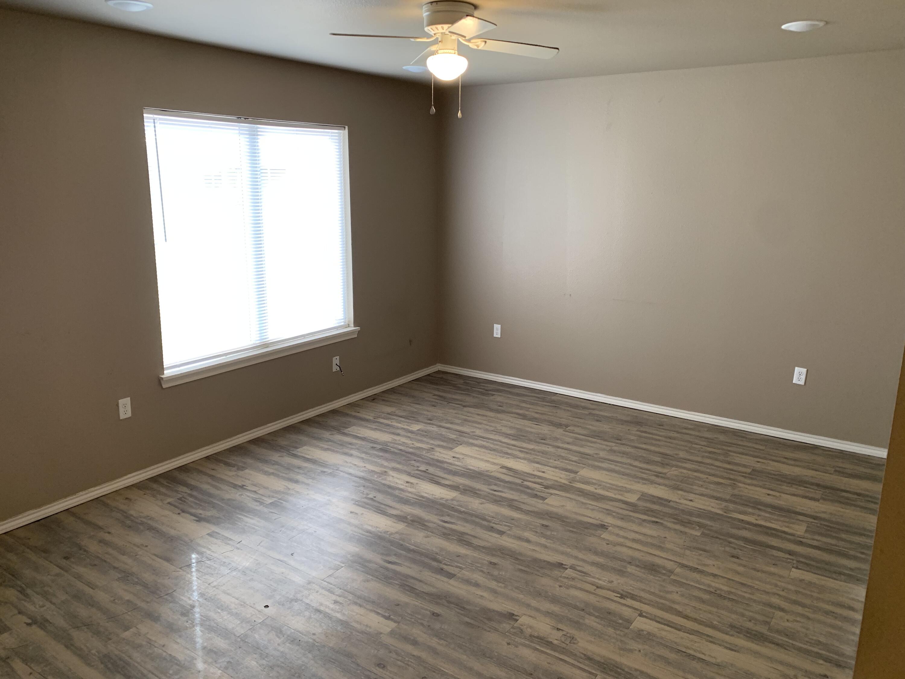 3611 East 3rd Place Lubbock, TX 79403 - Photo 3 of 8 wooden floor in an empty room with a window