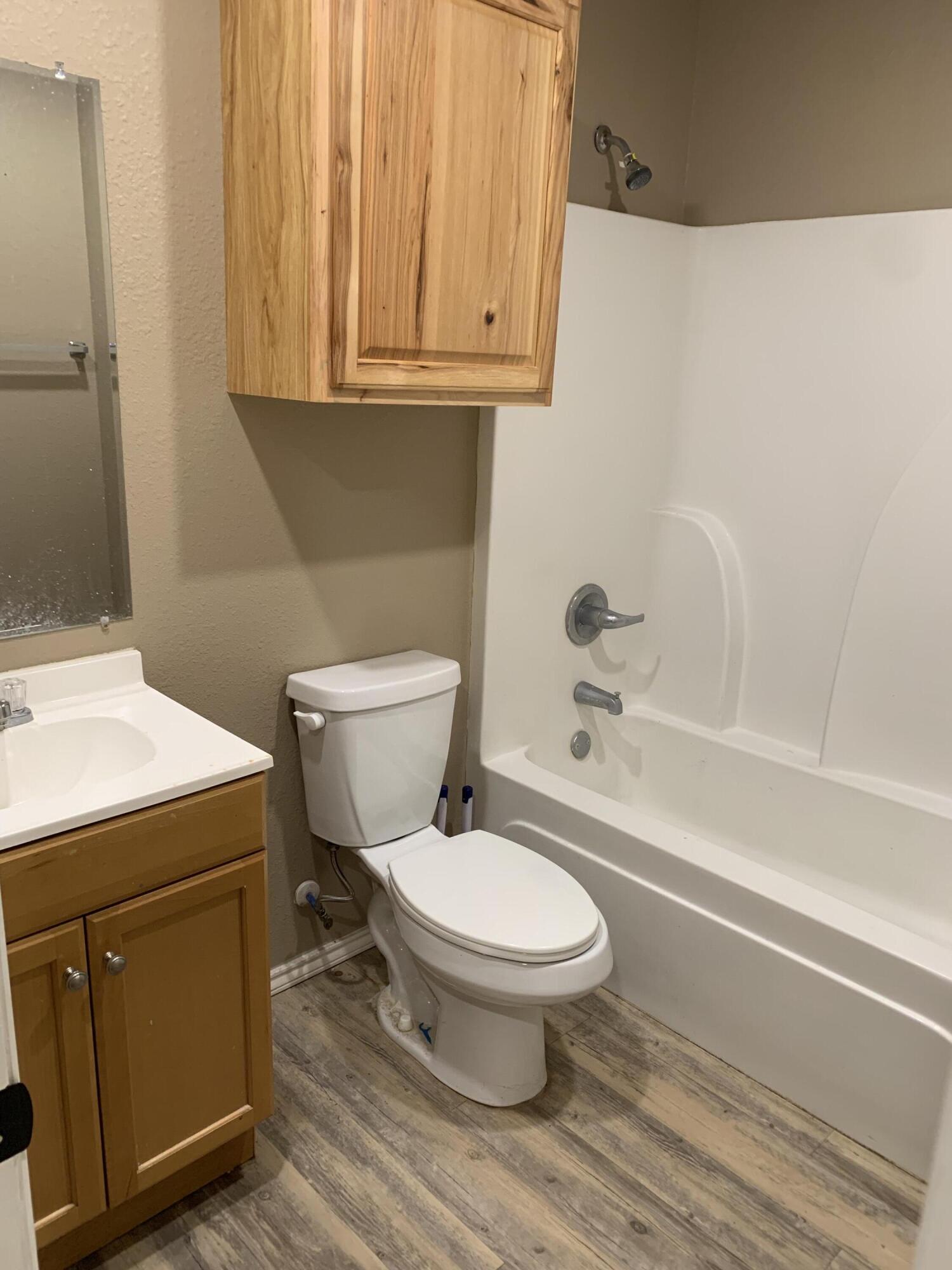 3611 East 3rd Place Lubbock, TX 79403 - Photo 6 of 8 a bathroom with a sink a toilet and bathtub