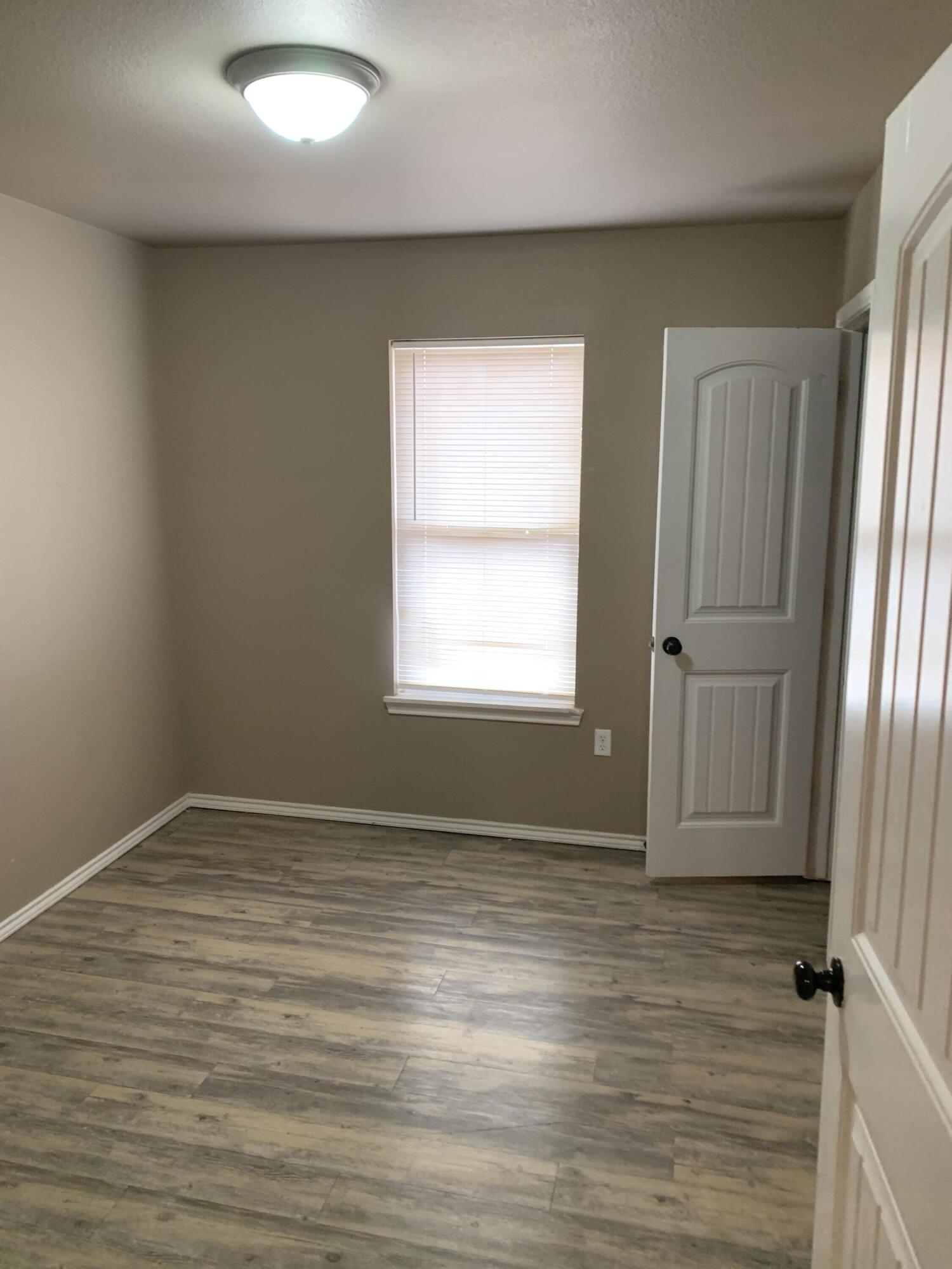 3611 East 3rd Place Lubbock, TX 79403 - Photo 7 of 8 an empty room with wooden floor and window
