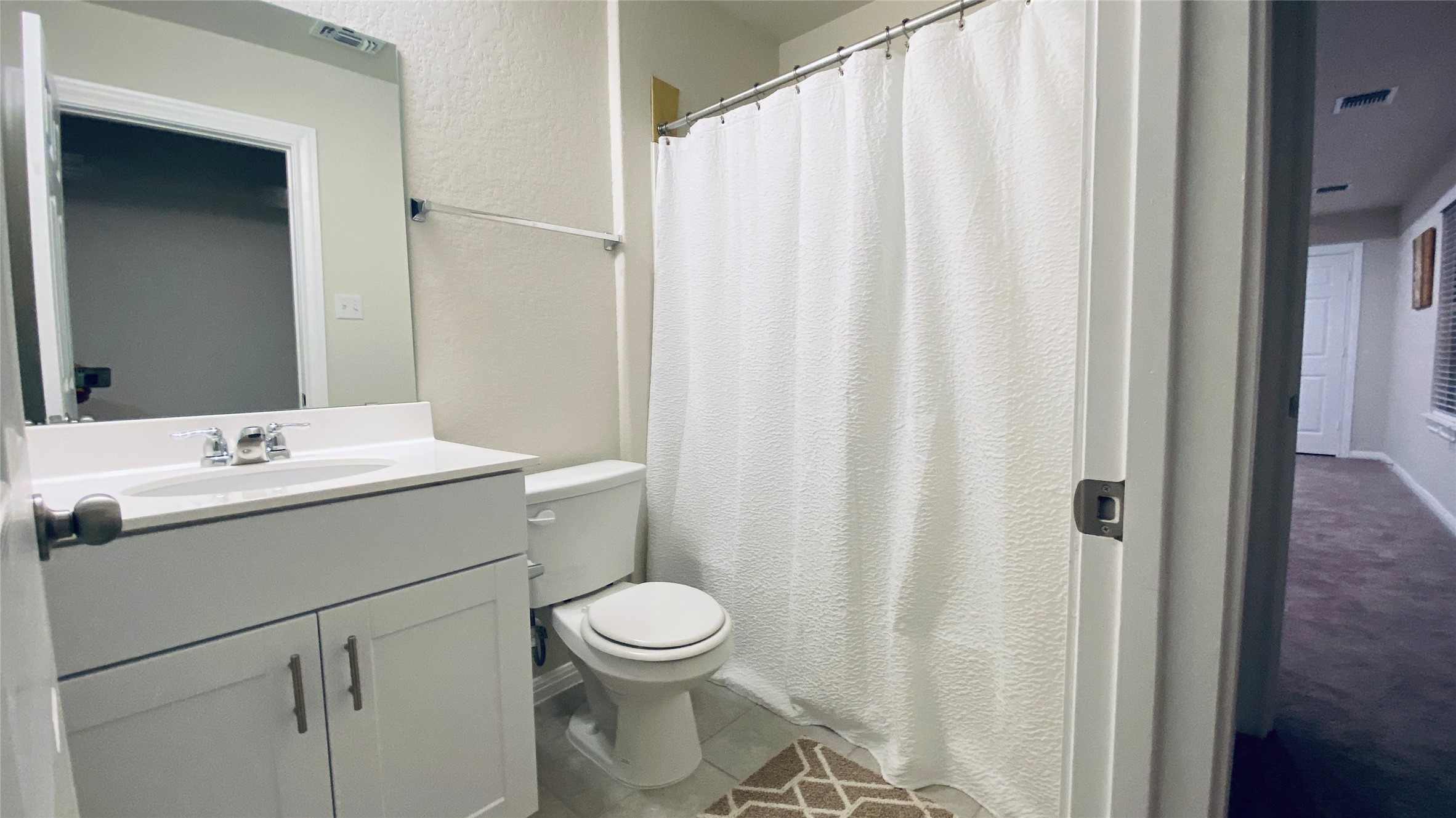 197 Prairie Falcon Way Leander, TX 78641 - Photo 18 of 29 Bathroom featuring curtained shower, vanity, and a textured wall
