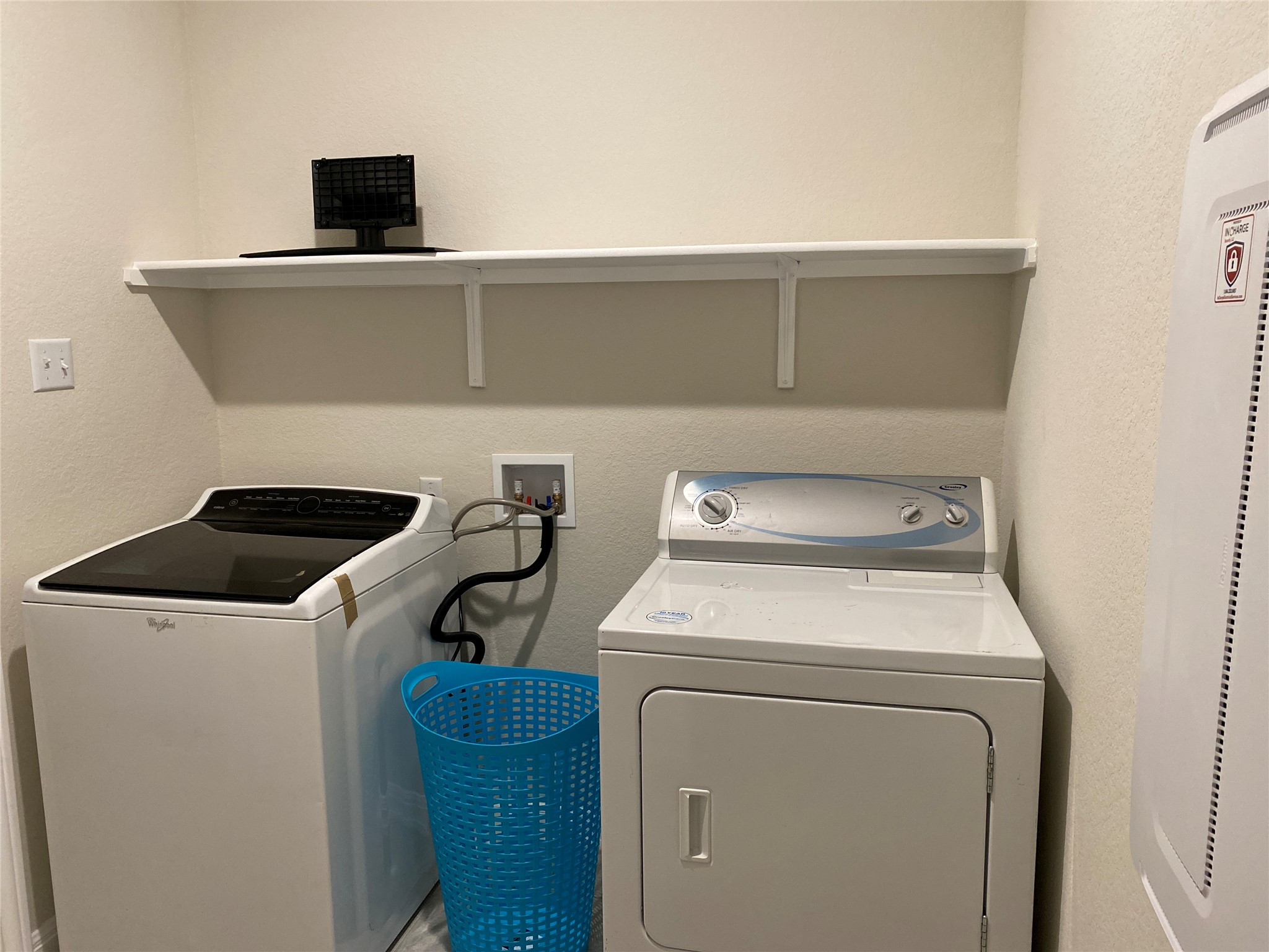 197 Prairie Falcon Way Leander, TX 78641 - Photo 21 of 29 Laundry area featuring a textured wall, water heater, and washing machine and clothes dryer