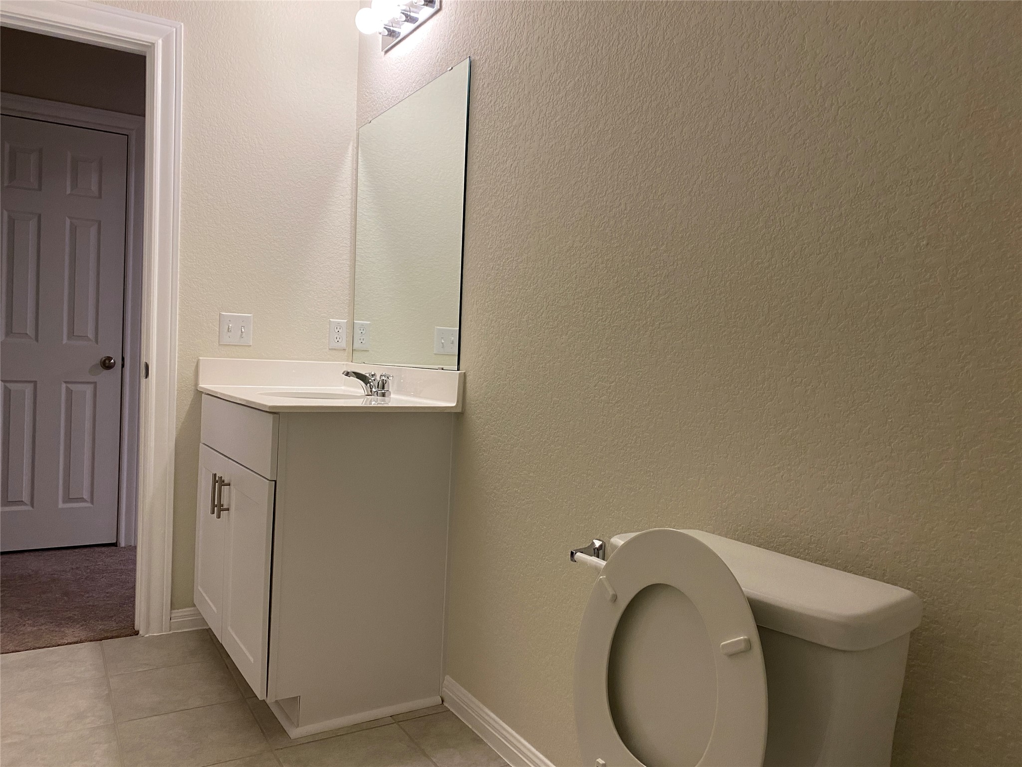 197 Prairie Falcon Way Leander, TX 78641 - Photo 27 of 29 Half bath with a textured wall, vanity, and light tile patterned floors