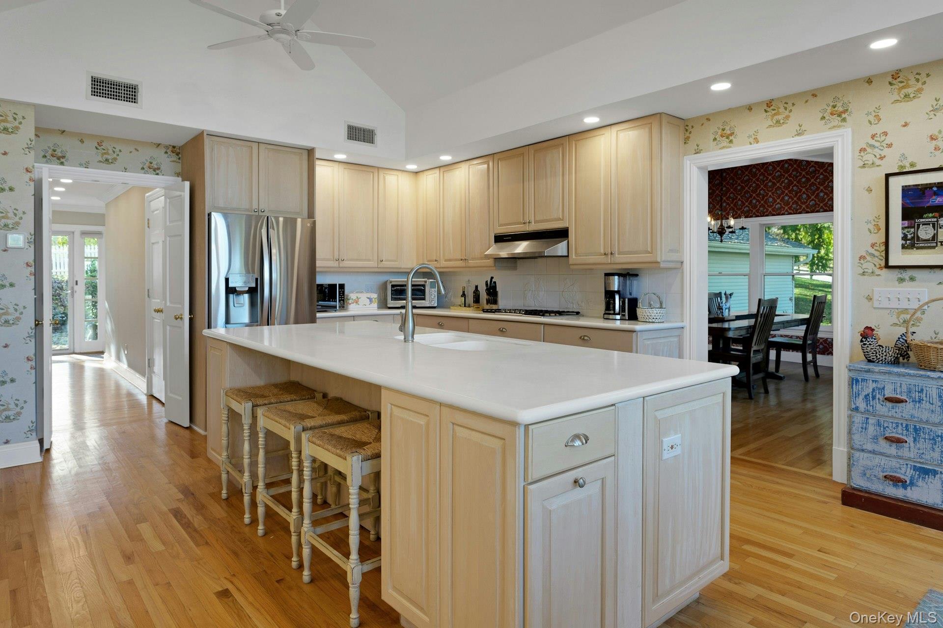 90 Cushman Road Patterson, NY 12563 - Photo 20 of 40 a kitchen with stainless steel appliances a sink a stove a refrigerator cabinets and a dining table with wooden floor