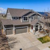 a view of a house with a yard and large tree