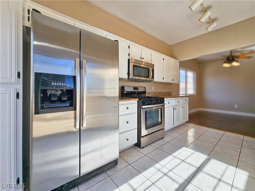 1851 Hillpointe Road, Unit 2124 Henderson, NV 89074 - Photo 10 of 24 Kitchen featuring white cabinetry, rail lighting, light tile patterned floors, and appliances with stainless steel finishes