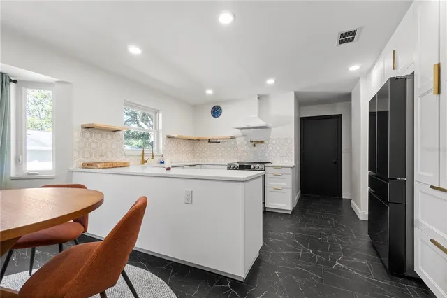 a kitchen with stainless steel appliances granite countertop a sink and a refrigerator