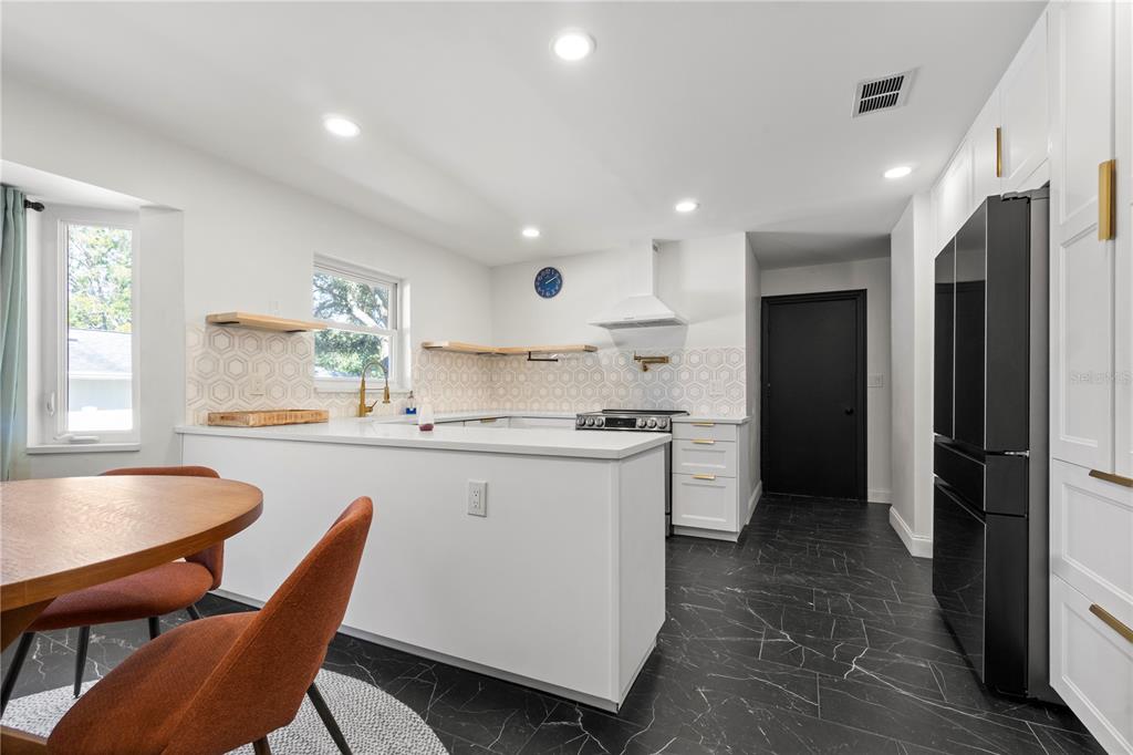 565 Sandy Hook Road Palm Harbor, FL 34683 - Photo 13 of 33 a kitchen with stainless steel appliances granite countertop a sink and a refrigerator