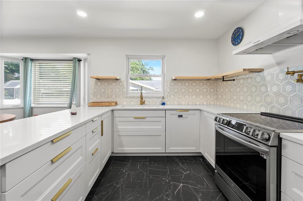 565 Sandy Hook Road Palm Harbor, FL 34683 - Photo 14 of 33 a kitchen with a stove oven and sink