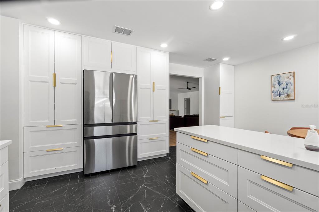 565 Sandy Hook Road Palm Harbor, FL 34683 - Photo 15 of 33 a kitchen with a refrigerator and white cabinets