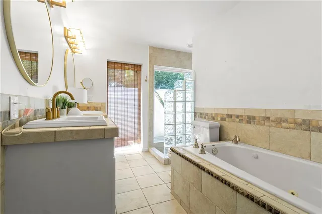 a bathroom with a tub sink and mirror