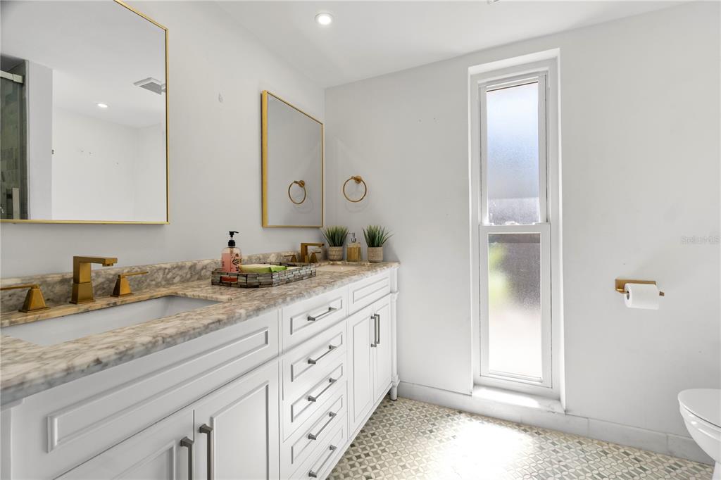565 Sandy Hook Road Palm Harbor, FL 34683 - Photo 21 of 33 a bathroom with granite countertop a sink and a mirror