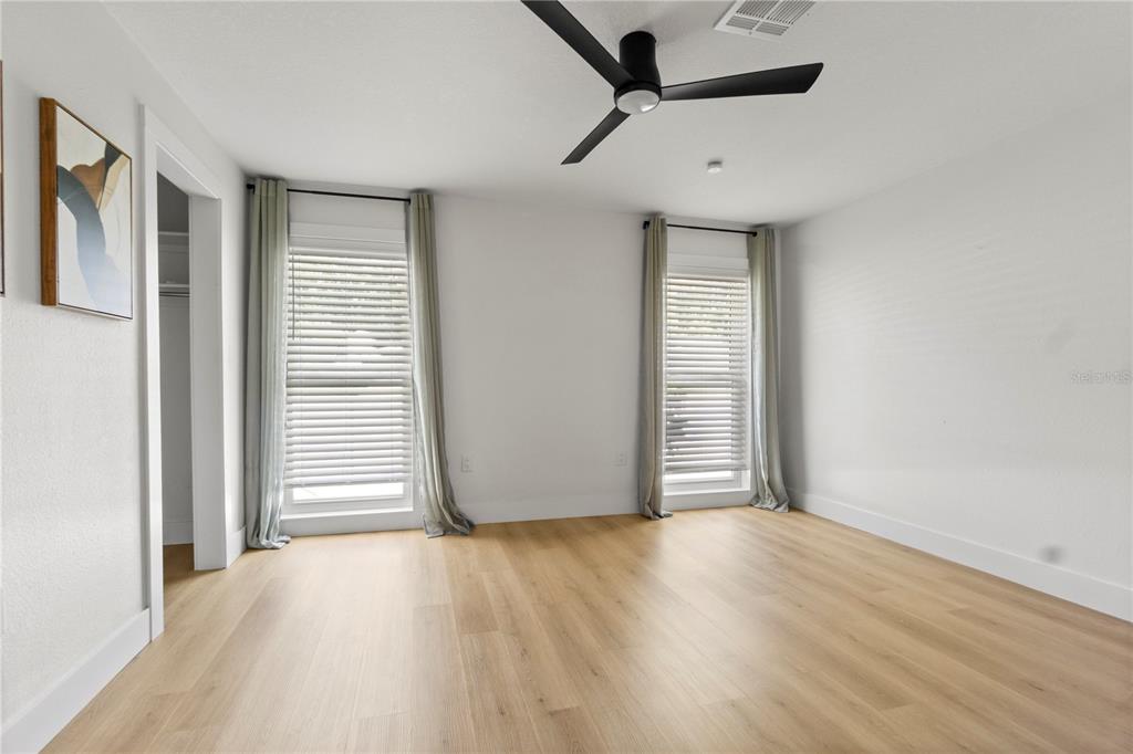 565 Sandy Hook Road Palm Harbor, FL 34683 - Photo 26 of 33 an empty room with wooden floor and windows
