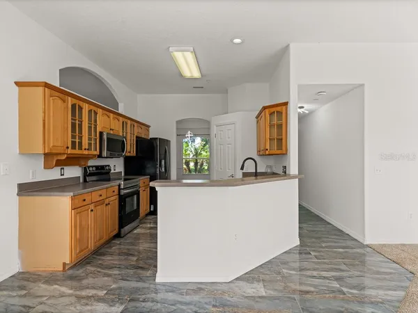 a living room with stainless steel appliances granite countertop furniture wooden floor and a view of kitchen