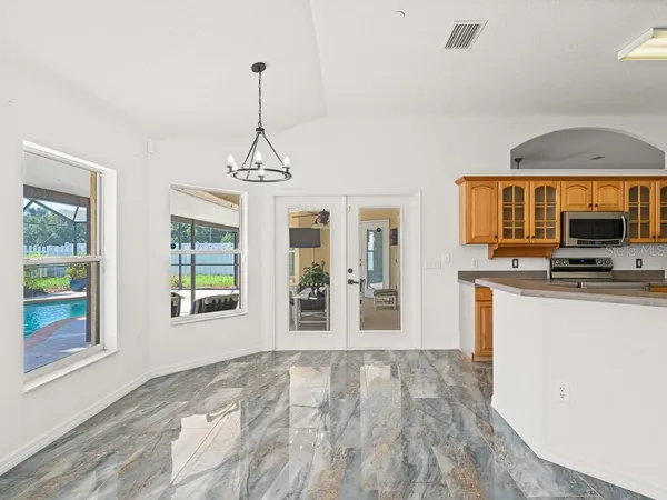 a view of a kitchen with granite countertop a stove top oven a sink a counter space and windows