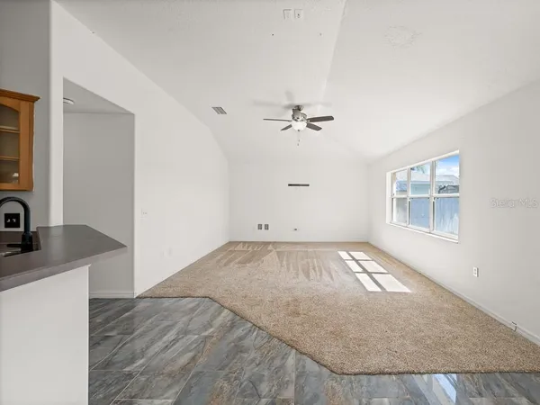 an empty room with a kitchen space and sink