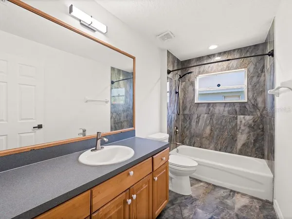 an empty room with a window and a ceiling fan