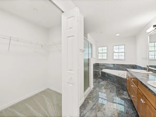 a spacious bathroom with a granite countertop tub sink and mirror