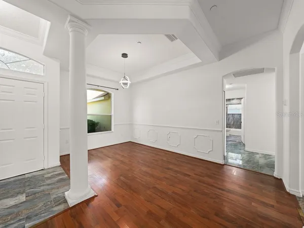an empty room with wooden floor and mirror