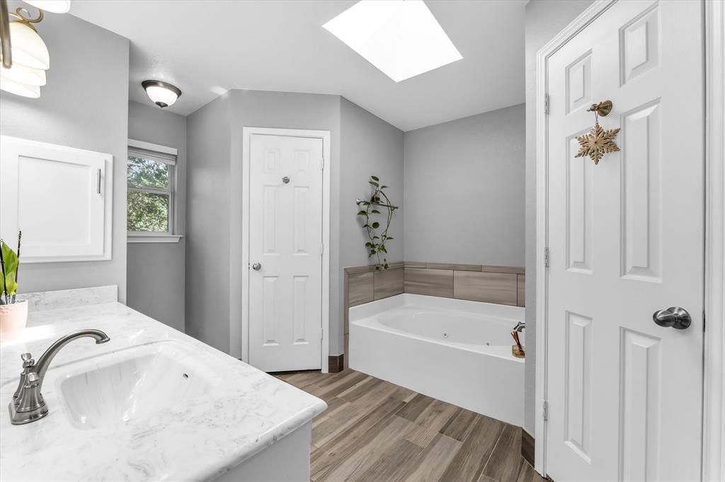 7 Market Loop Morgan's Point Resort, TX 76513 - Photo 16 of 31 Bathroom featuring a spacious vanity with a white countertop, brushed nickel fixtures, faux wood-finish flooring, and white cabinetry
