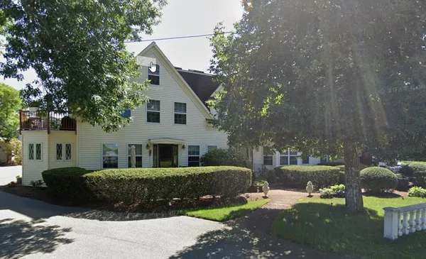 a front view of a house with a garden